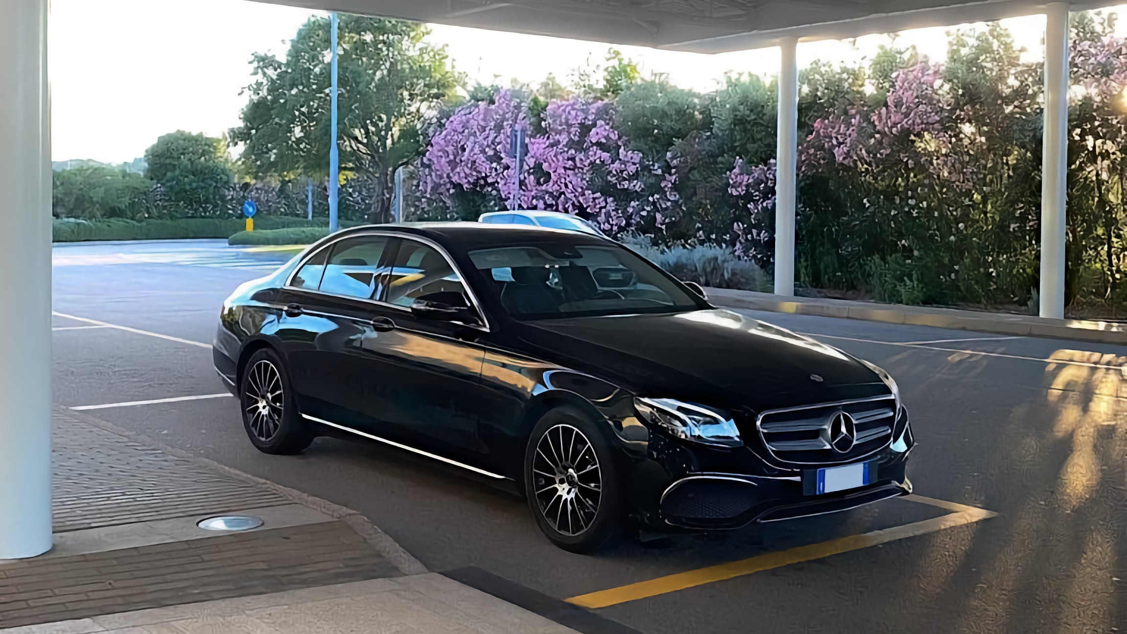 Una Mercedes Classe E della flotta Sardegnatours parcheggiata all'aeroporto di Olbia in attesa del transfer verso Palau di un cliente